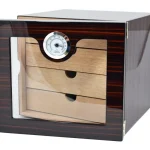 Acest Humidor trabucuri de birou este un accesoriu de lux și esențial pentru pasionații de trabucuri care își doresc să păstreze produsele lor în condiții optime de umiditate.