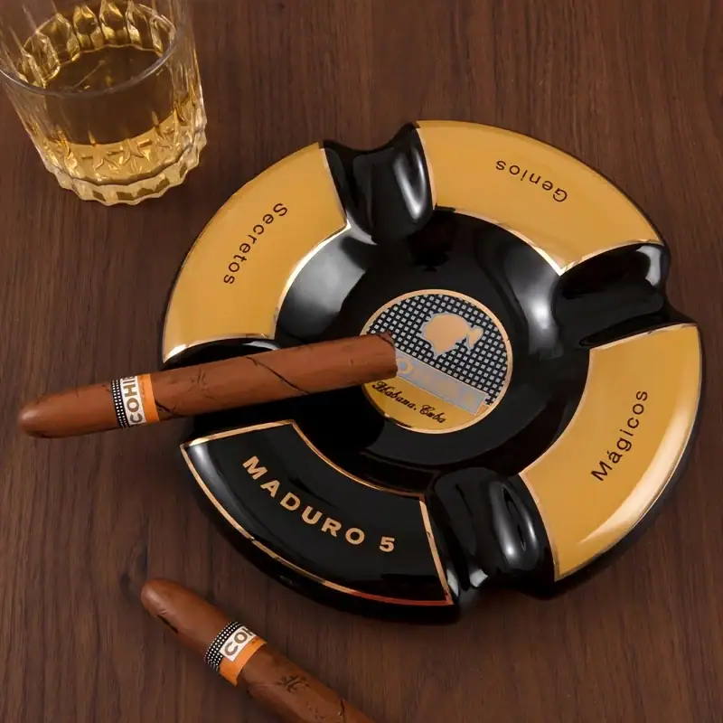 Scrumieră Cohiba elegantă cu trabuc și pahar de rom lângă