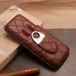 Etui 3 trabucuri piele naturală Cigarloong închis, sprijinit de o cutie de trabucuri Partagas, cu trabuc Partagas lângă, prezentând designul elegant și luxul produsului