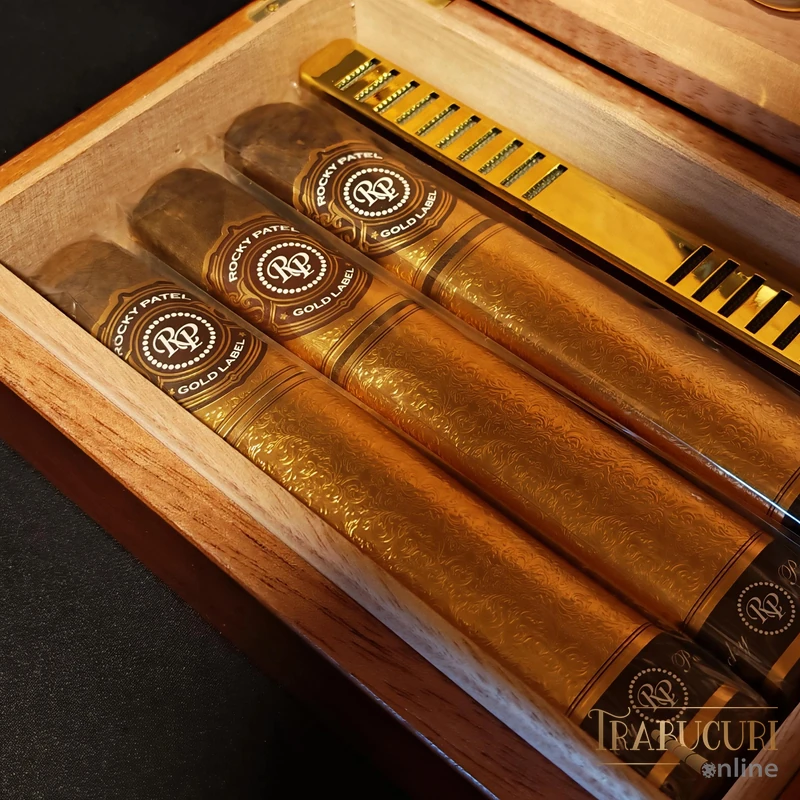 Detaliu cu trei trabucuri Rocky Patel Gold Label Sixty așezate în humidorul din lemn